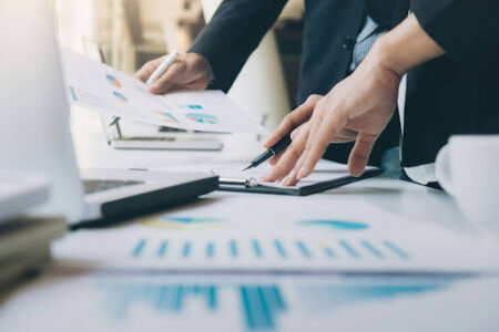 Two business people standing over a desk examining various charts, for “5 Defining Trends in Alternative Assets - Can You Identify Them All?”