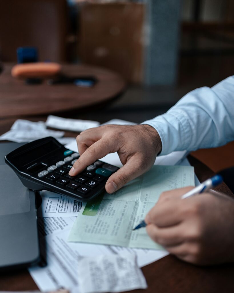 Someone using a calculator to fill in tax forms, for "How Tax-Efficient Is Your Portfolio? Take our Quiz"