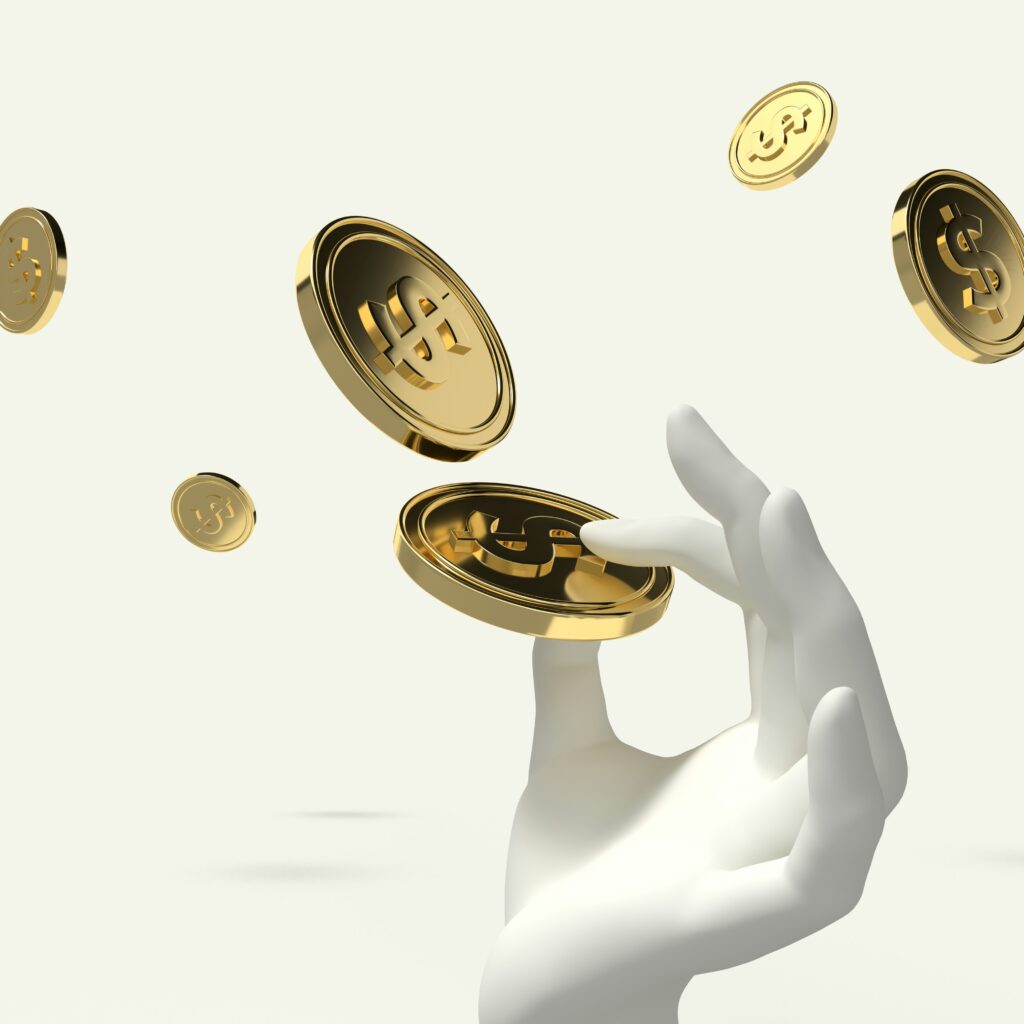 A hand holding a golden coin whilst other coins fall from above, for “How Do Tokenized Assets Work in Alternative Investments, and Are They Safe?”