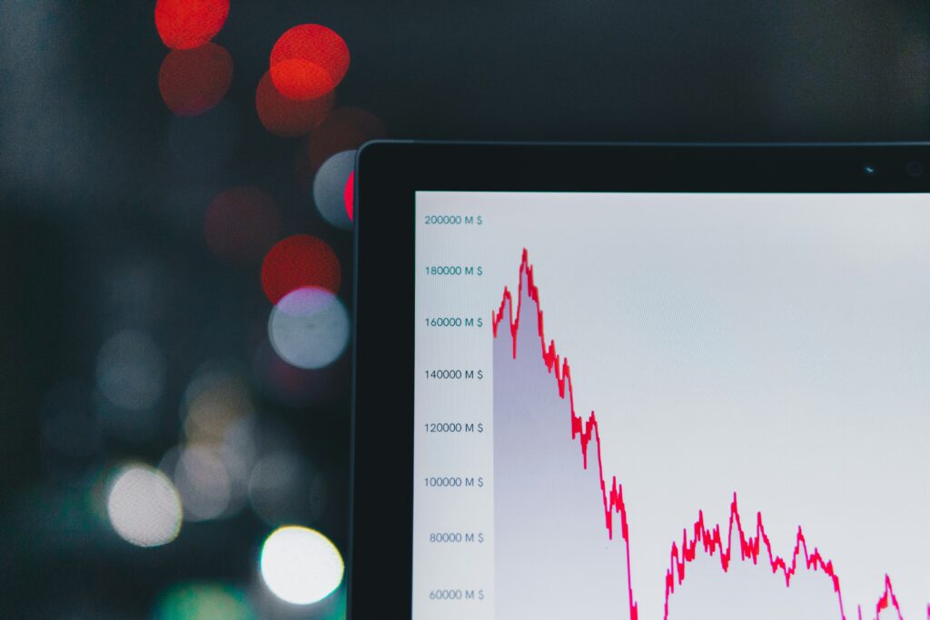 A laptop screen showing a red downward graph, for “Can Alternative Assets Outperform Stocks During a Market Crash?”