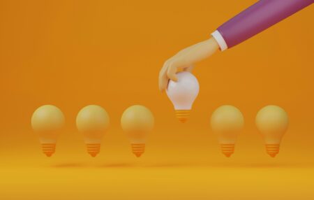A hand holding a white light bulb above several other orange bulbs, “How the Ultra-Wealthy Reduce Tax Burdens with Alternative Investments”